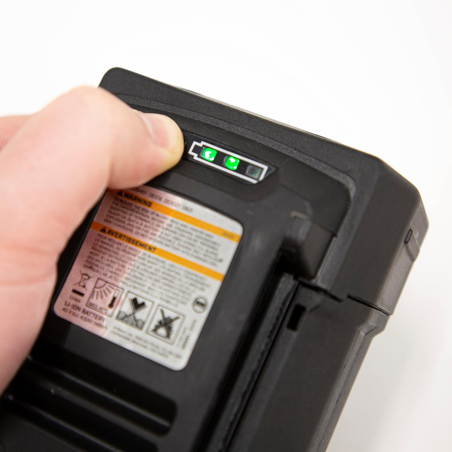 Close-up of ION battery's built-in LED charge level indicator being activated by hand