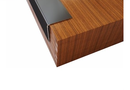 Wooden surface displaying aluminum corner guard on a white background