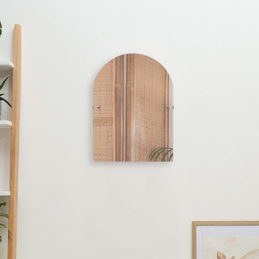 Arch teal tilt beveled edge mirror mounted on white wall and greenery flowers for decoration