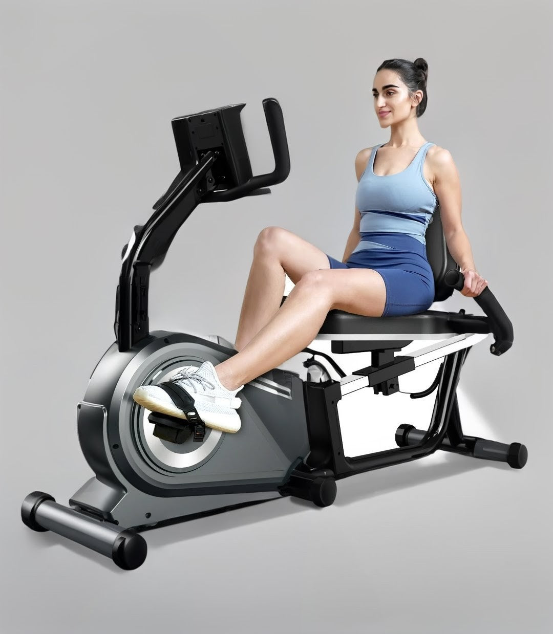 Woman exercising on a recumbent bike against a gray background