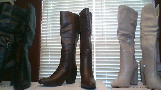 Front view of three pairs of women’s knee-high boots in size 6, featuring black, chocolate brown, and tan faux leather with side zippers and mid heels
