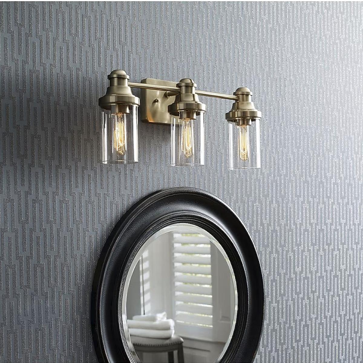Allen + Roth Ivy 3-Light Vanity Light installed in a bathroom with a champagne finish and clear glass shades, providing elegant illumination.